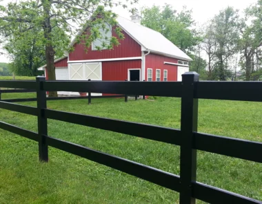 Coronado aluminum post and rail fence in black around barn yard