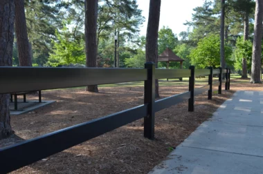 Coronado aluminum post and rail fence in black along side walk