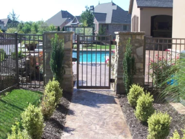 metal picket fence gate between stone pillars