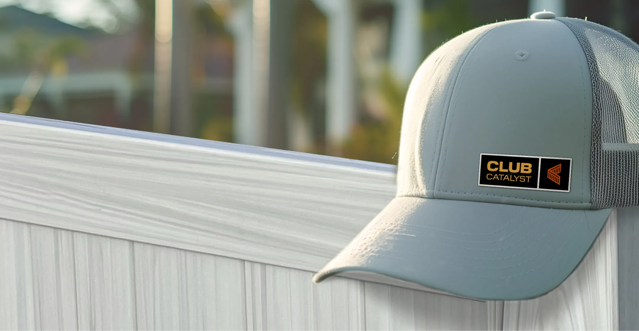 Club Catalyst hat on a weathered aspen vinyl privacy fence