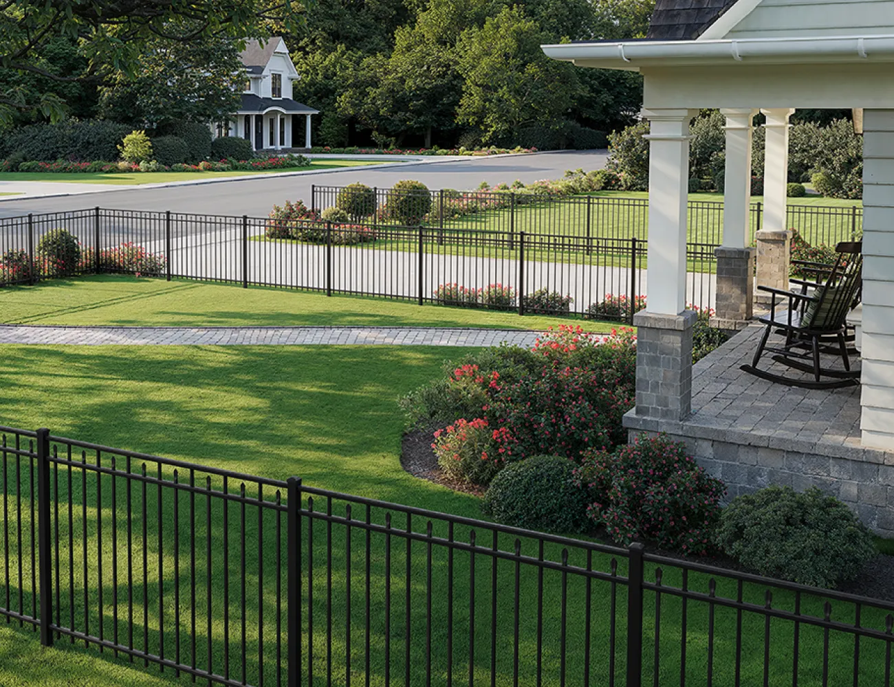 porch overlooking front yard surrounded by black metal picket fence